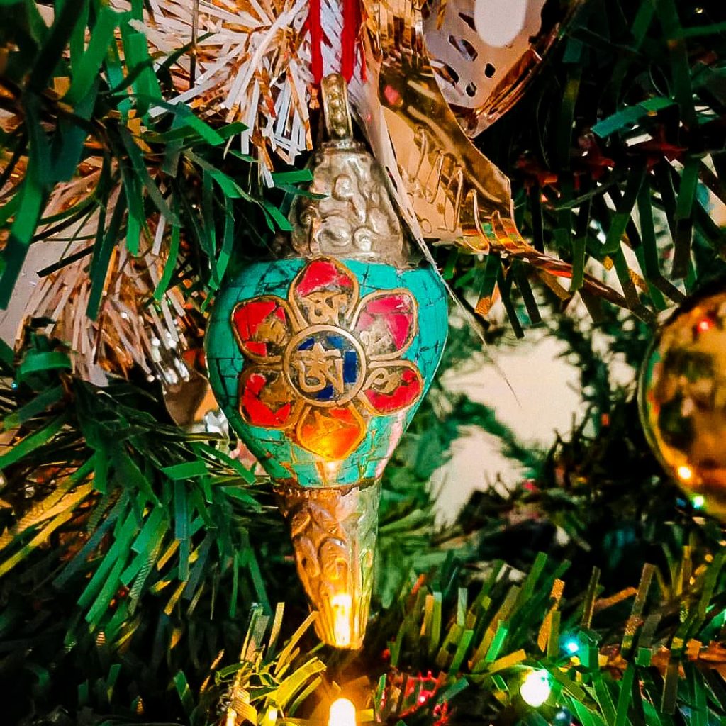 A Tibetan charm made from a seashell hanging on a Christmas tree.