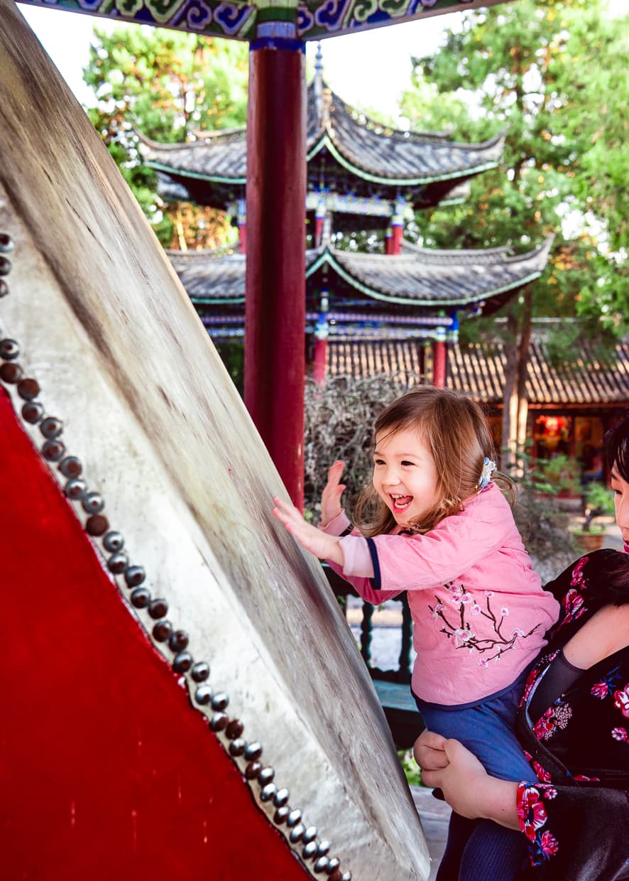 Lijiang, China, playing a big drum near Wangu Tower.