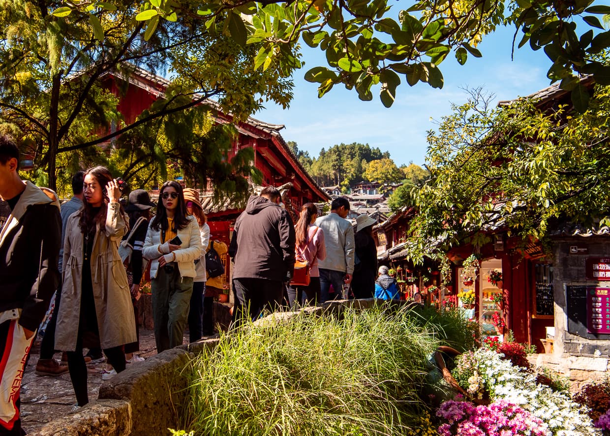 Tourists navigating a bridge in the Lijiang Old Town.
