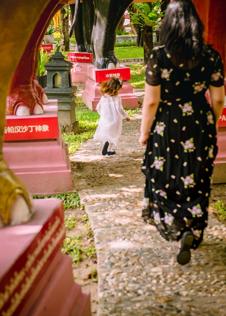 Walking between the legs of elephant statues.