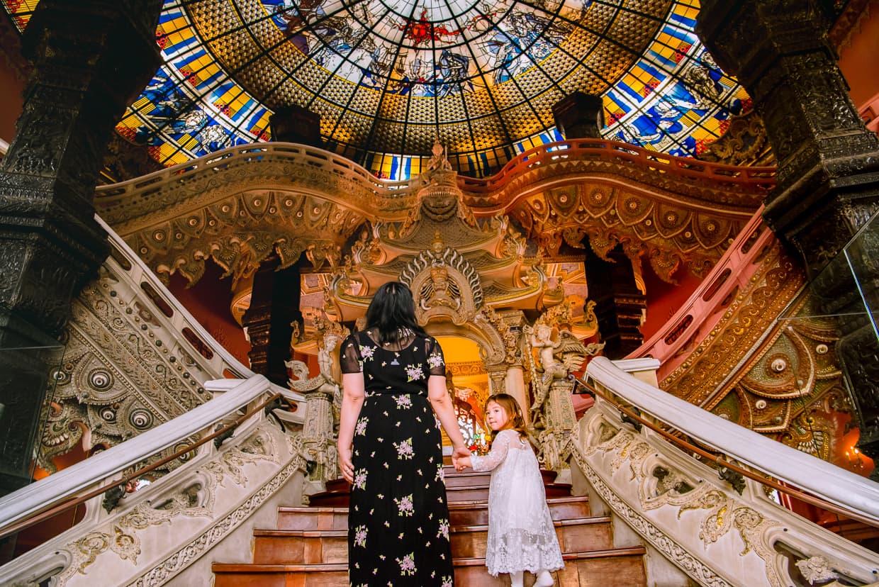 Mother and Daughter entering the Erawan Museum and walking up the stairs.