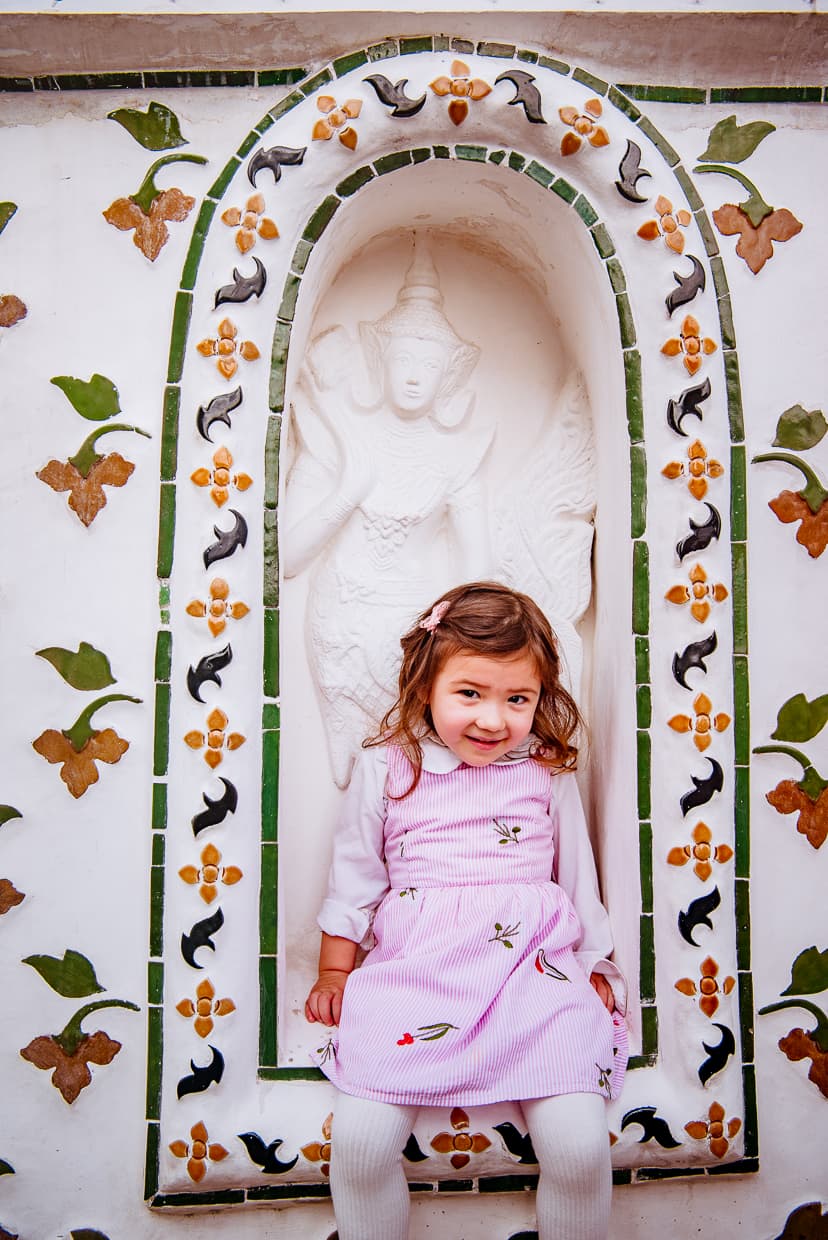 Lisa sitting in front of a Buddha statue at Wat Arun.