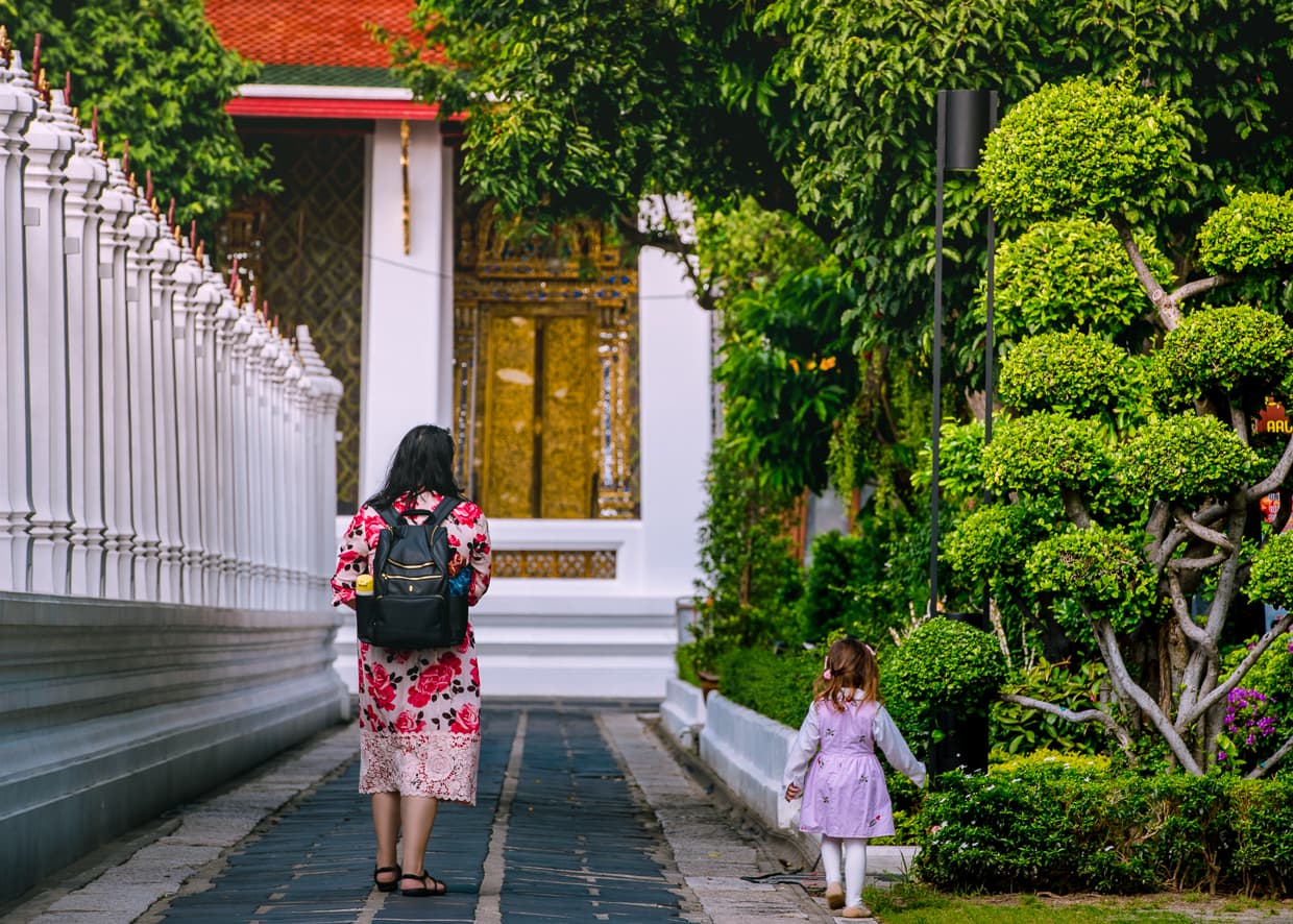 Family walking in the gardens outside Wat Arun.