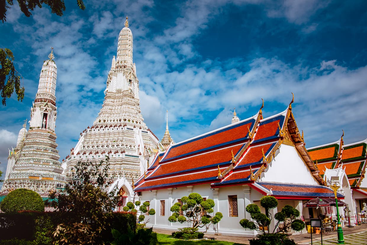 Wat Arun in Bangkok, Thailand under a blue sky.