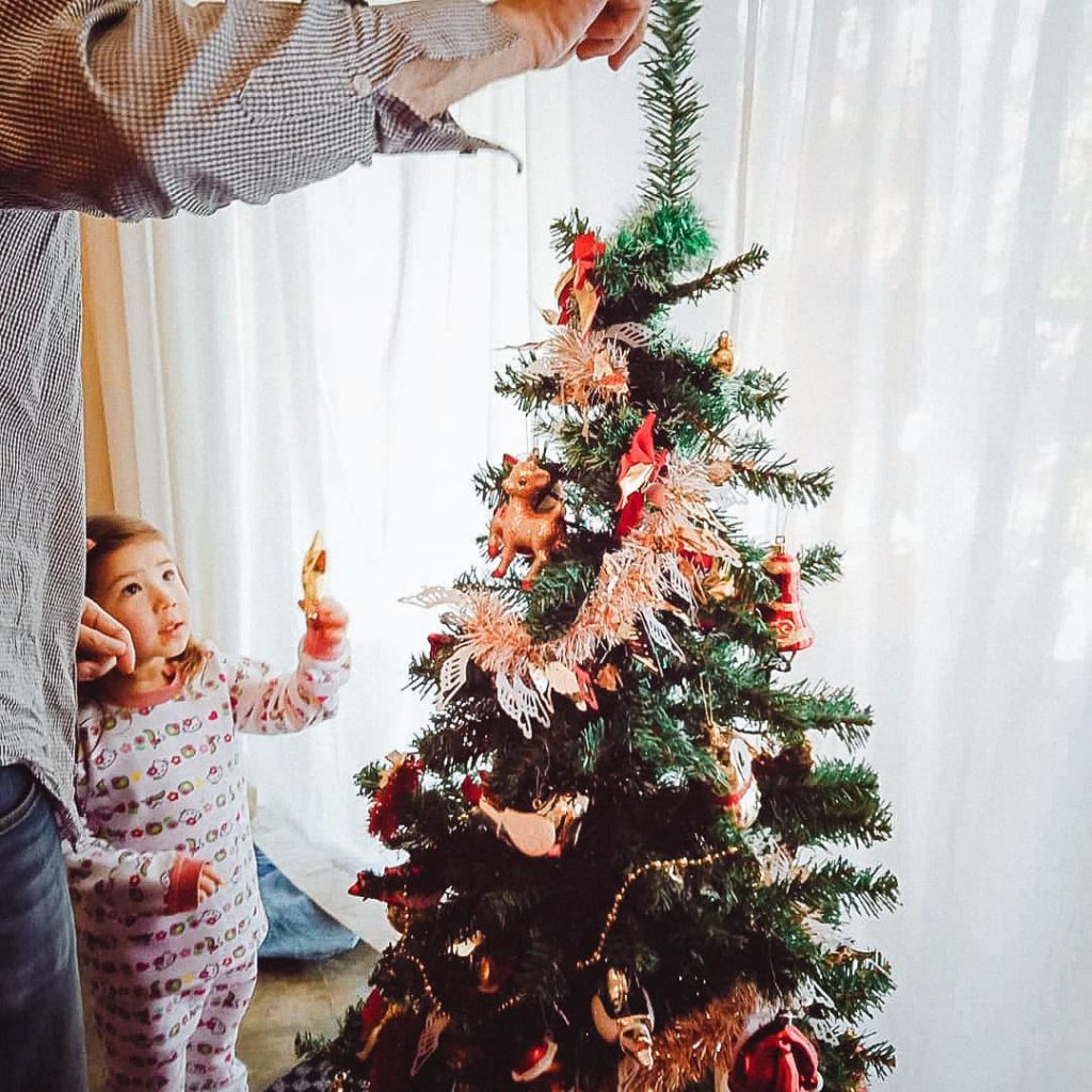 Father and daughter decorating the Christmas tree.