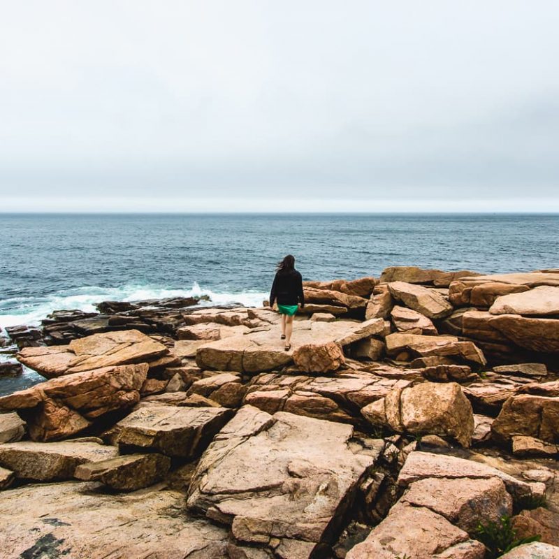 Climbing on rocks in Acadia National Park. Bar Harbor Maine.