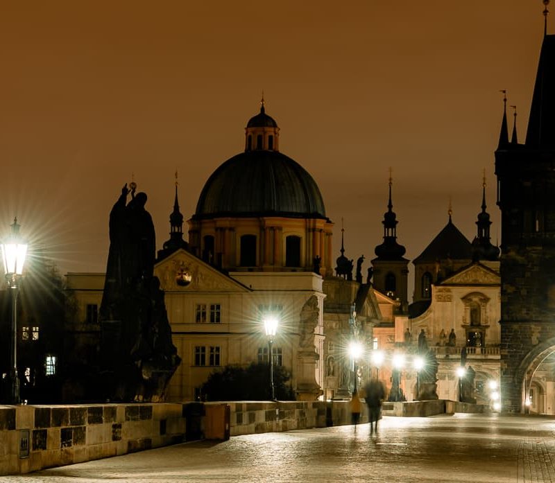 Prague's Charles Bridge at night with lamp light.