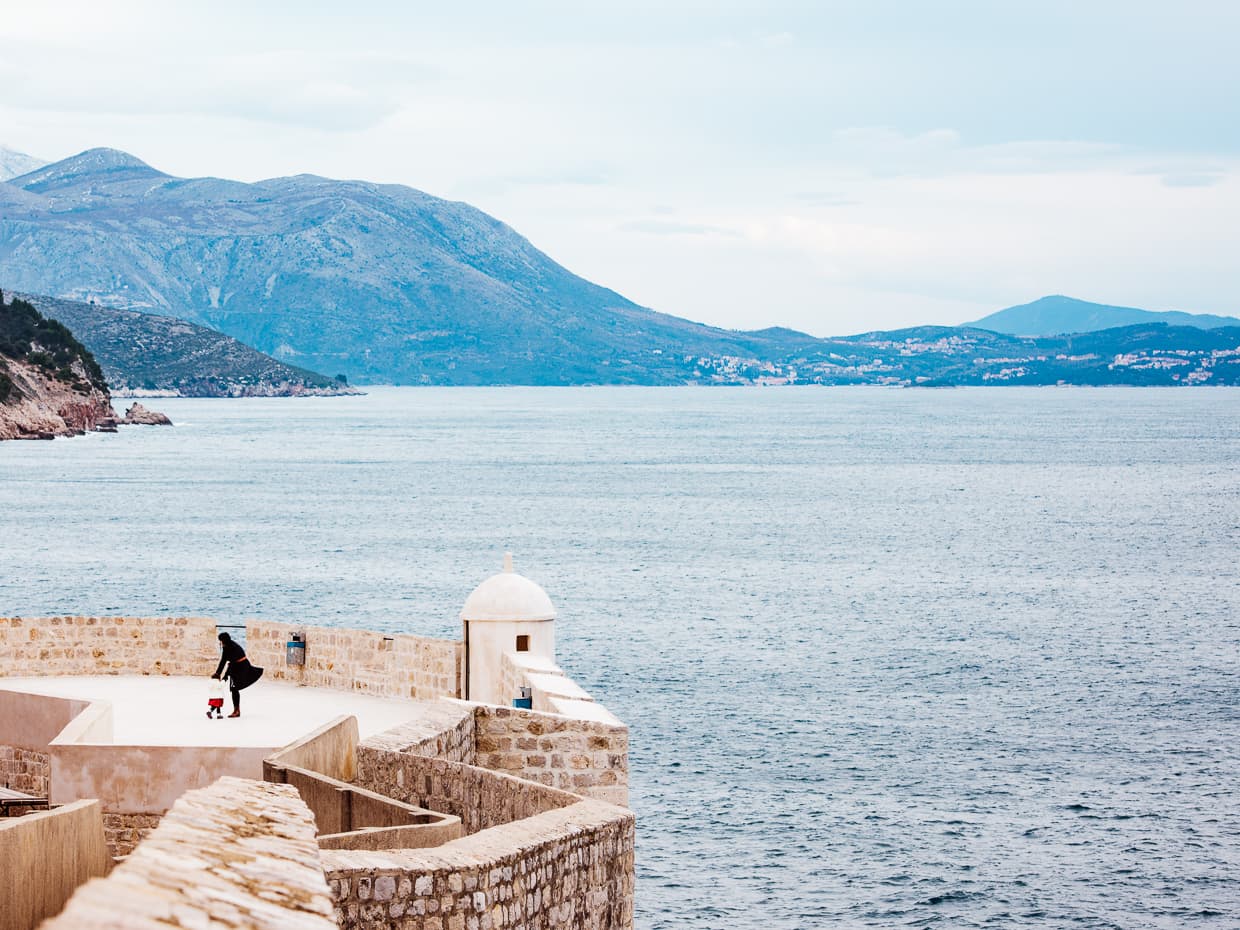 exploring the Dubrovnik, Croatia city walls with the Adriatic Sea as a backdrop.