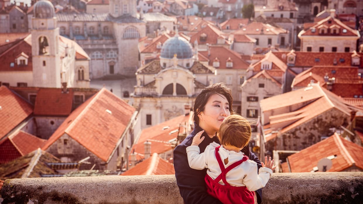 Holding Lisa on the city walls of Dubrovnik with the rooftops and cathedrals in the background.