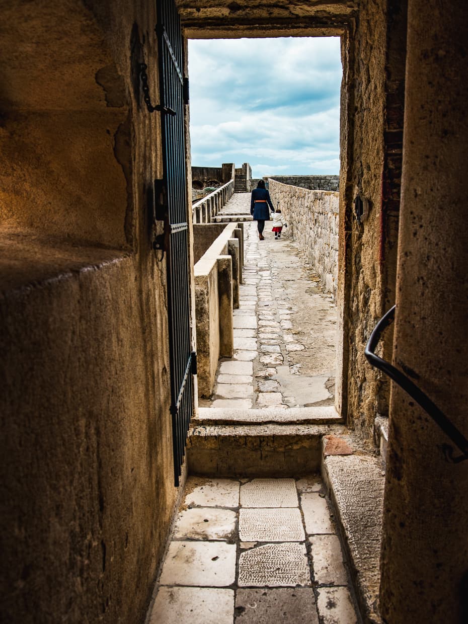 looking down a long stretch of the city walls that surround Dubrovnik, Croatia.