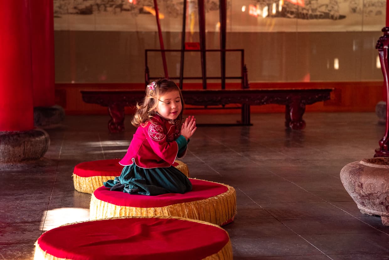 Girl praying in a Buddhist temple in Lijiang, China.
