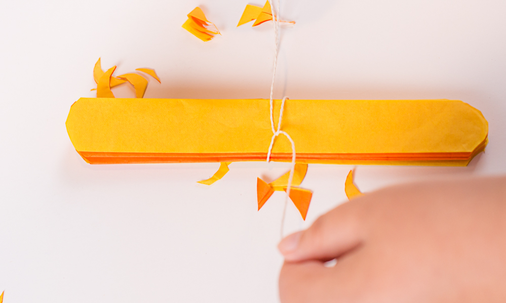 tie a piece of string around the tissue paper in the middle. That will be the center of the flower