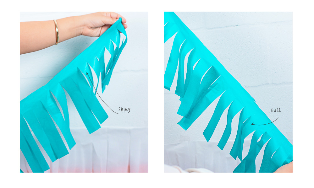 Dannie holds the fringed tissue paper up against the wall