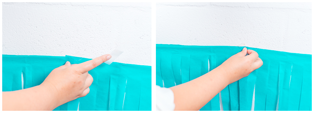 Using tape, Dannie attaches the backdrop the the garage wall