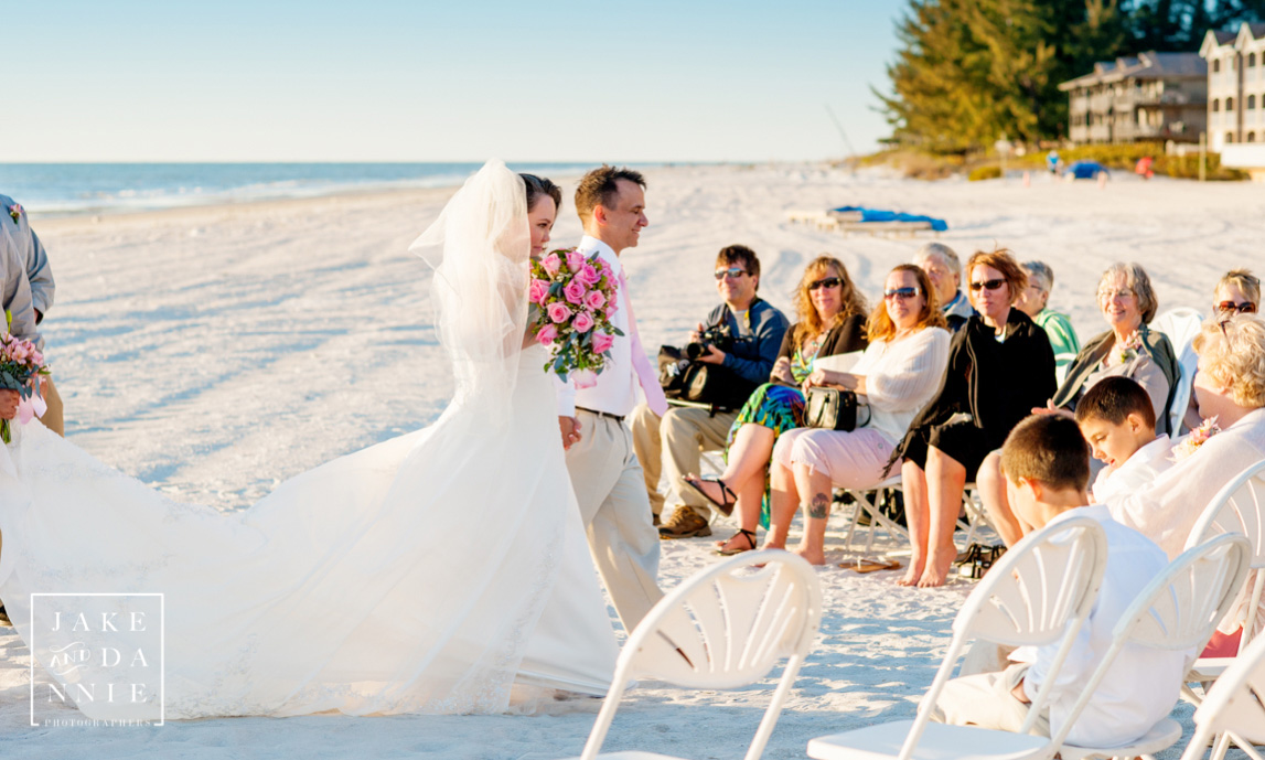 After being married on the beach the bride and groom walk triumphantly back up the aisle to the Civitan Beach Club in St. Petersburg, Fl.