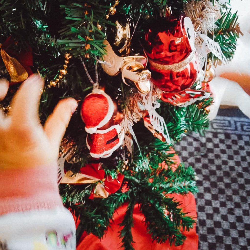 Lisa's little hands putting ornaments on the Christmas tree.