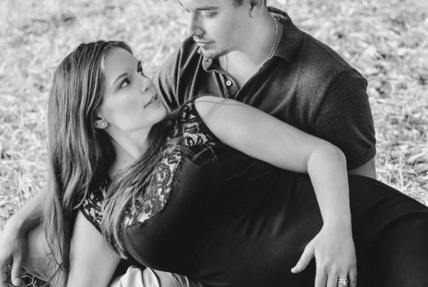 Couple rests in the grass during maternity photo session