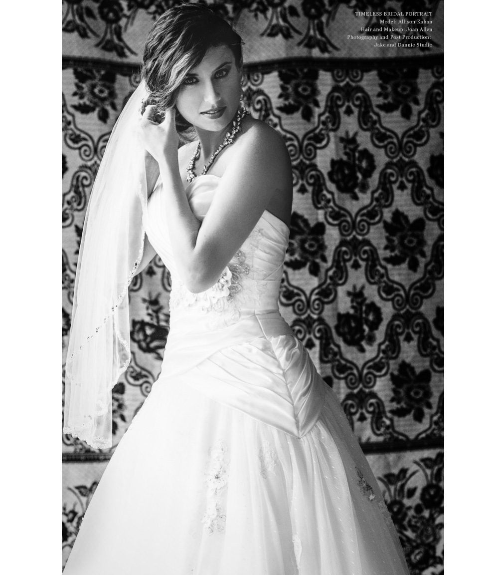 A bride fixes her veil in the window light