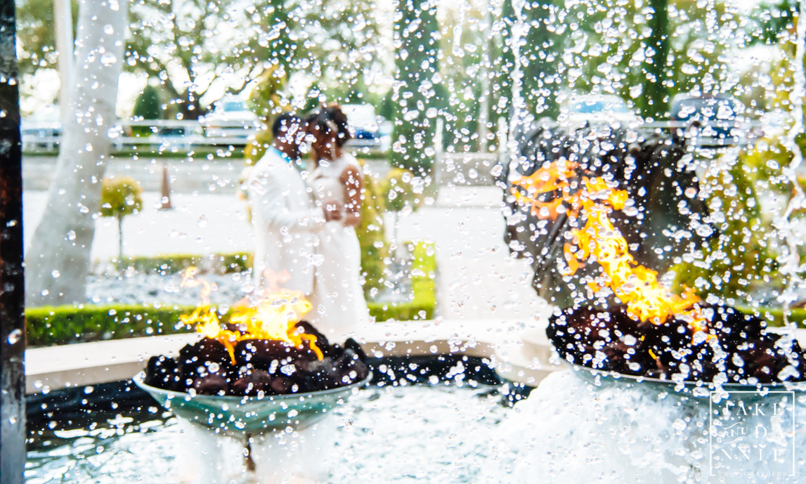 newly married couple kisses behind the waterfall and flames at T pepin's hospitality center in Tampa, Florida