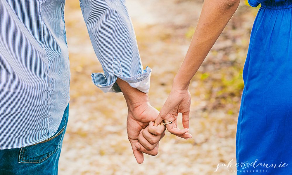 Couple walks through park holding hands in romantic photo