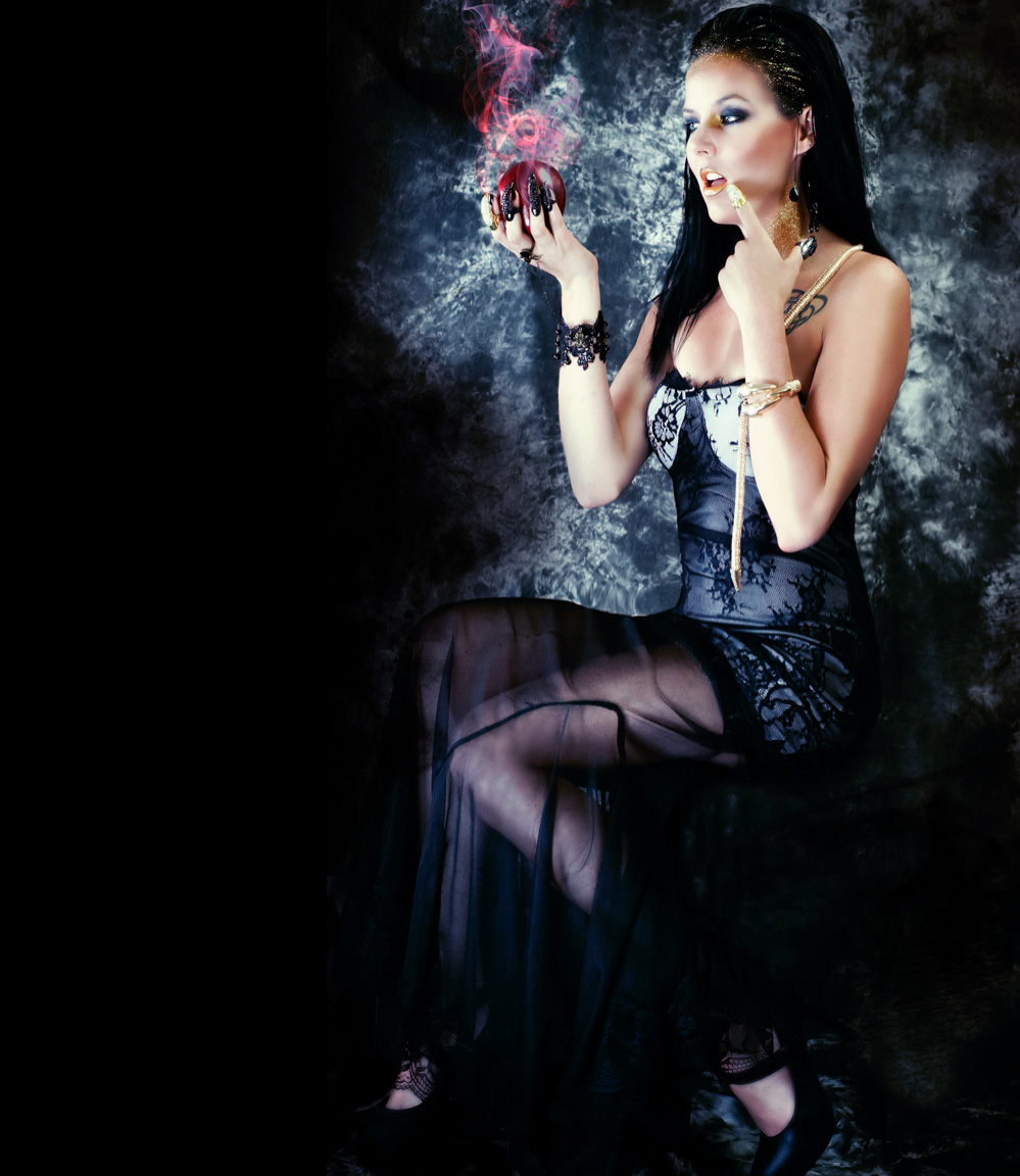 sexy halloween sorceress with claws holds eveil magic apple