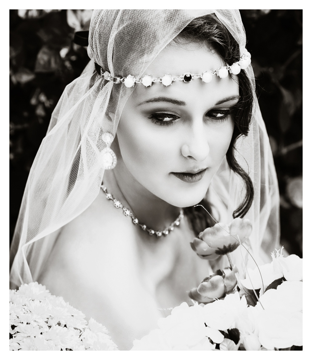 A bride looks over her shoulder wearing a veil