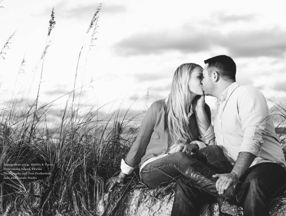 couple kisses in the grass near the beach as sunset approaches