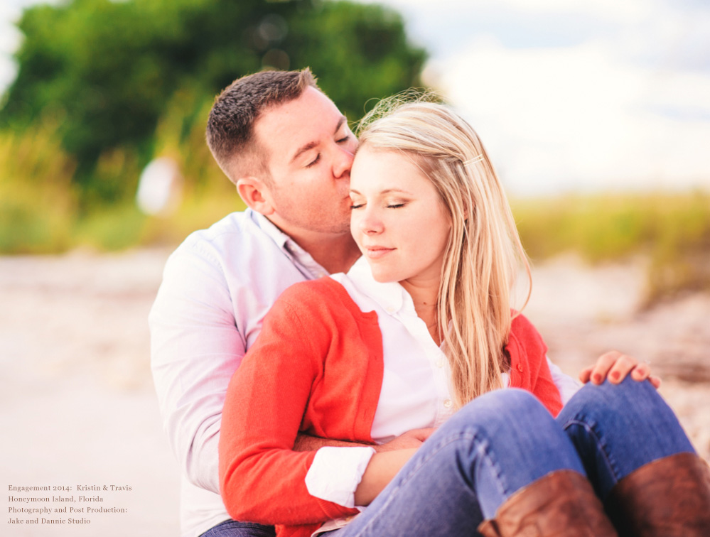 Sitting couple share a kiss on the beach